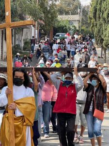 Parishioner carrying a cross leads a Good Friday procession